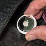 A person placing an Apple Air Tag in someone's wallet without their knowledge.